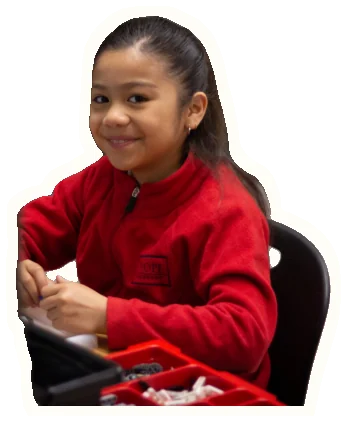 An older createMPLS student in a red school fleece, smiling at her build table.